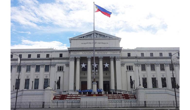 Front view of the National Museum with the Philippine flag at Manila, Philippines.