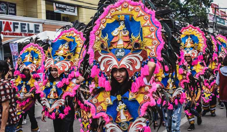 a group of people wearing a costume for Sinulog Festival in the Philippines