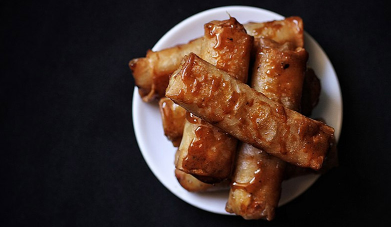Turon is sliced bananas wrapped in a spring roll wrapper, it's rolled in sugar and deep fried